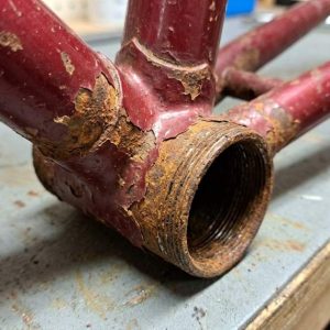 Removing rust from an old steel frame with a wire brush